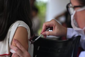 Una profesional de la salud aplica una dosis de la vacuna contra el dengue