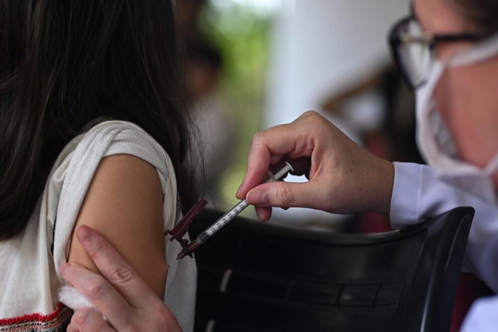 Una profesional de la salud aplica una dosis de la vacuna contra el dengue