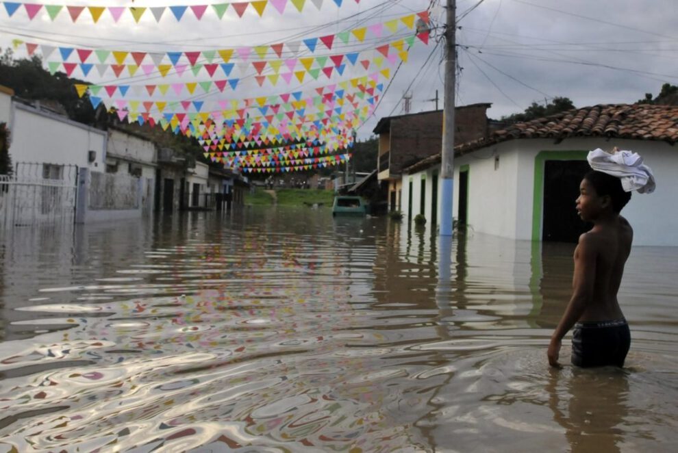 Un niño camina por una calle hoy inundada en Cali como consecuencia del fenómeno climatológico de La Niña