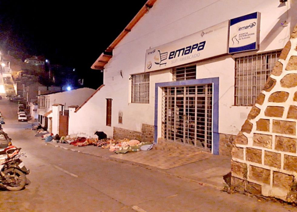 Personas durmiendo sobre la acera esperando comprar arroz en Sucre