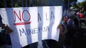 Una persona sostiene una pancarta durante una manifestación sobre minería metálica en El Salvador