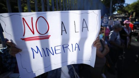 Una persona sostiene una pancarta durante una manifestación sobre minería metálica en El Salvador