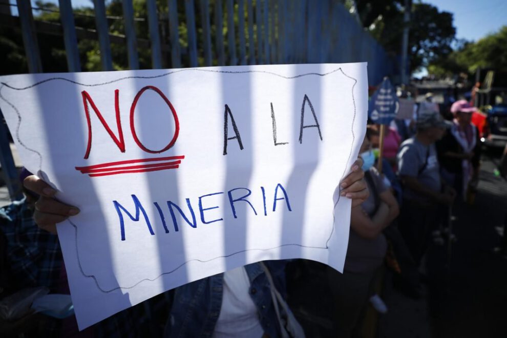 Una persona sostiene una pancarta durante una manifestación sobre minería metálica en El Salvador