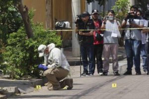 Investigadores de la Policía Boliviana recogen los casquillos de las balas disparadas en un ataque armado en Santa Cruz