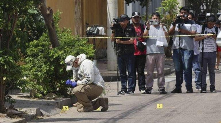 Investigadores de la Policía Boliviana recogen los casquillos de las balas disparadas en un ataque armado en Santa Cruz