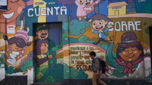 Una persona camina frente a un mural alusivo a la niñez