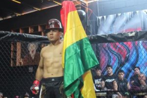 agapito con casco minero y la bandera de bolivia