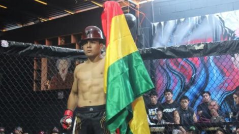 agapito con casco minero y la bandera de bolivia