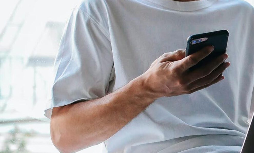 Imagen referencial de un hombre sujetando un teléfono