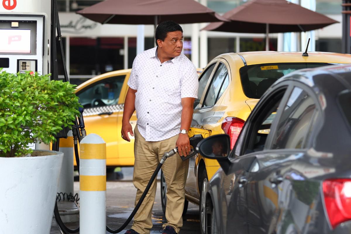 un señor cargando combustible