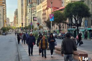 Personas en el Prado paceño caminando ante la falta de transporte