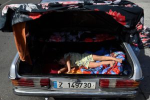 Un niño desplazado, que duerme en el maletero de un coche en una calle de Beirut
