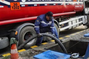 Persona descargando cumbustible en una estacion de servicio
