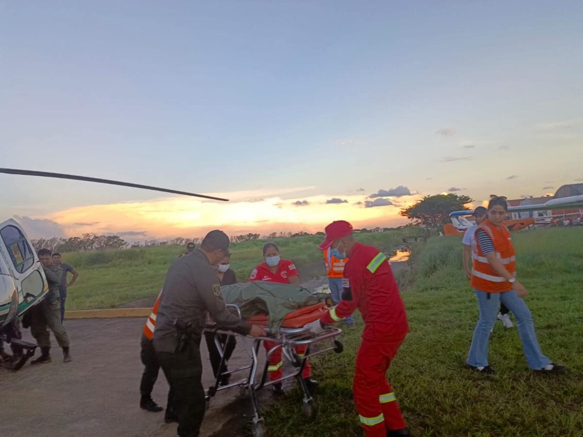 Personal de emergencia y efectivos militares realizan el traslado de uno de los tripulantes fallecidos