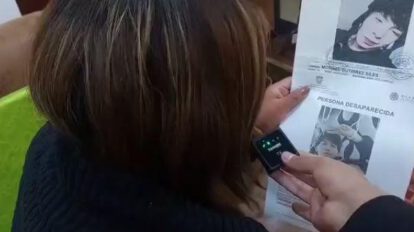 Madre de Michael mostrando el cartel de desaparecido
