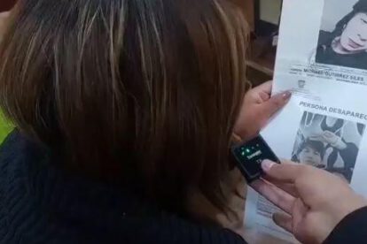 Madre de Michael mostrando el cartel de desaparecido