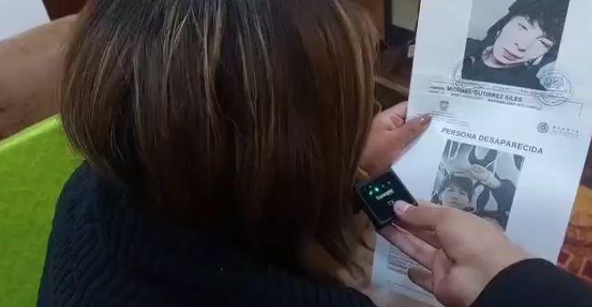 Madre de Michael mostrando el cartel de desaparecido