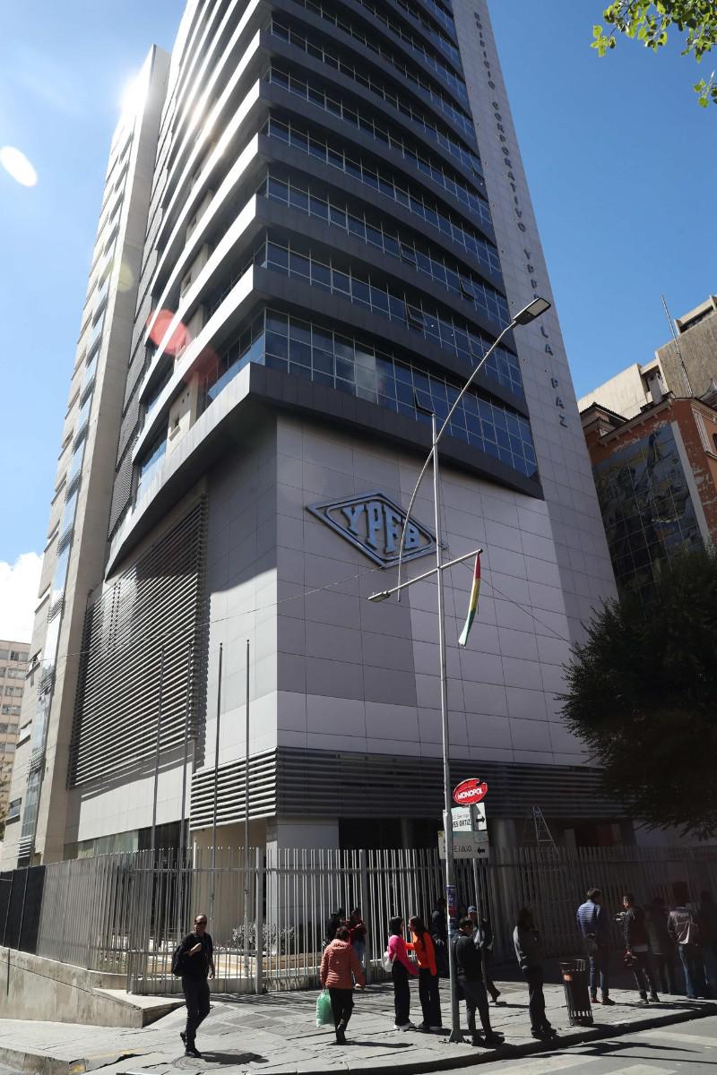 Personas caminan frente al edificio de YPFB