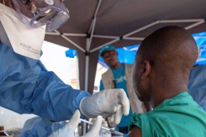 Trabajador de la salud le inyecta la vacuna contra el ébola a un paciente