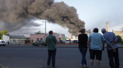 La gente observa nube de humo de incendio en el fondo después de un ataque con misiles en Odesa, Ucrania