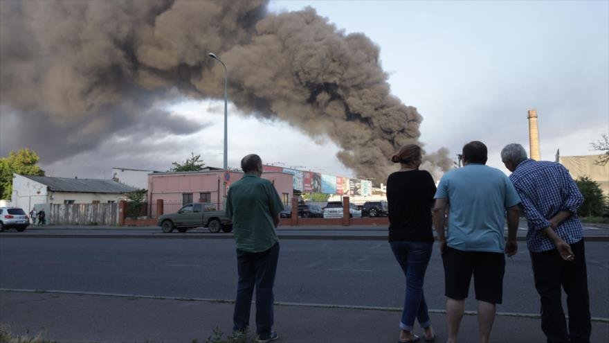 La gente observa nube de humo de incendio en el fondo después de un ataque con misiles en Odesa, Ucrania