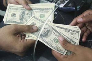 Usuario recibiendo dólares en el banco