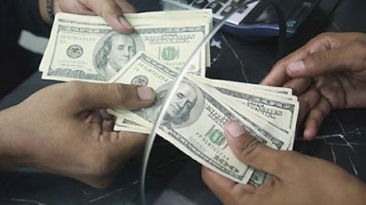 Usuario recibiendo dólares en el banco