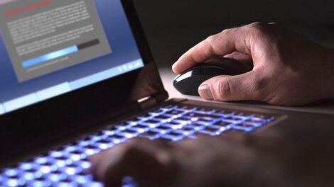 Un hombre mirando su computadora sobre apuestas ilegales en línea