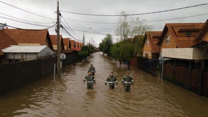 Tragedia climática en Chile: Rescatistas caminan por una calle inundada tras el desborde del río Claro