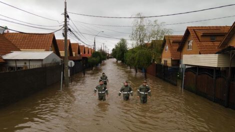 Tragedia climática en Chile: Rescatistas caminan por una calle inundada tras el desborde del río Claro