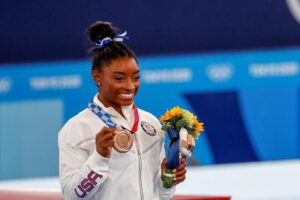 Simone Biles celebra en el podio tras conseguir la medalla de bronce en los Juegos Olímpicos 2020