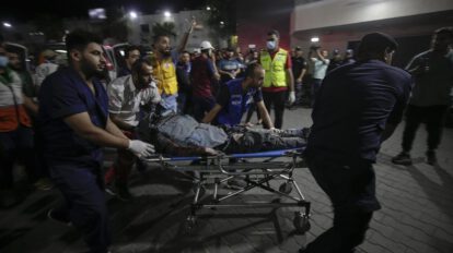 Vista de personas que llevan a un periodista palestino herido en Gaza