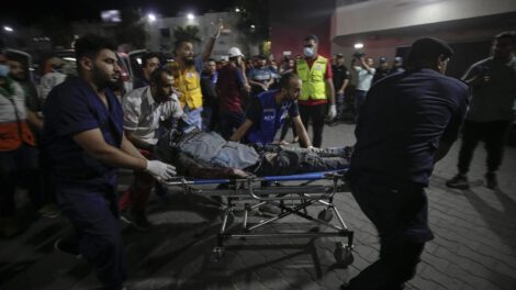 Vista de personas que llevan a un periodista palestino herido en Gaza