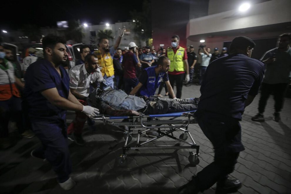 Vista de personas que llevan a un periodista palestino herido en Gaza