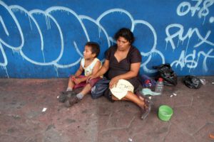 Niño salvadoreño de escasos recursos junto a su madre sobre los Objetivos de Desarrollo Sostenible