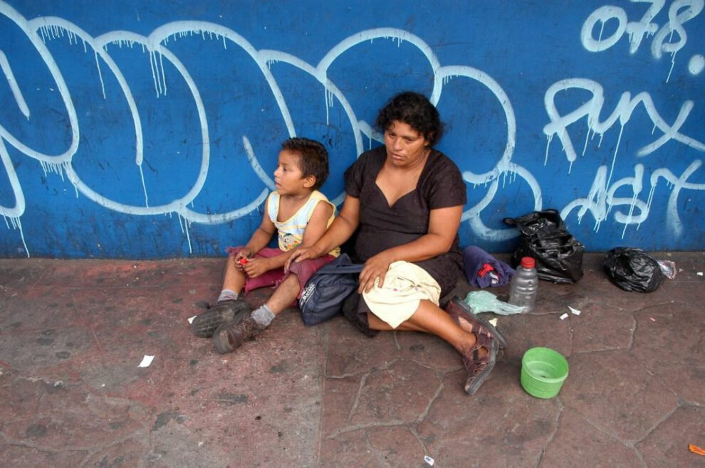 Niño salvadoreño de escasos recursos junto a su madre sobre los Objetivos de Desarrollo Sostenible