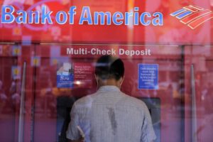Un hombre saca dinero de un cajero automático en una sucursal del Bank of America