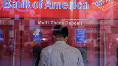 Un hombre saca dinero de un cajero automático en una sucursal del Bank of America