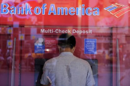 Un hombre saca dinero de un cajero automático en una sucursal del Bank of America