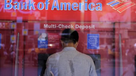 Un hombre saca dinero de un cajero automático en una sucursal del Bank of America