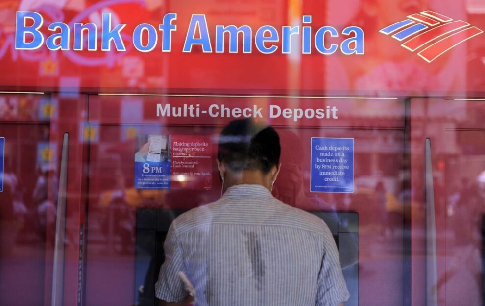 Un hombre saca dinero de un cajero automático en una sucursal del Bank of America