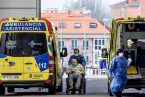 Un sanitario lleva a un enfermo a la puerta de urgencias de un hospital