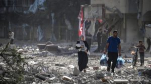 Una familia palestina entre los escombros de los edificios alcanzados en un bombardeo israelí sobre el barrio de Tel al-Hawa, en Gaza