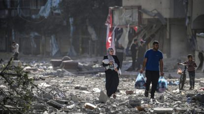 Una familia palestina entre los escombros de los edificios alcanzados en un bombardeo israelí sobre el barrio de Tel al-Hawa, en Gaza