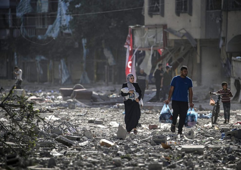 Una familia palestina entre los escombros de los edificios alcanzados en un bombardeo israelí sobre el barrio de Tel al-Hawa, en Gaza