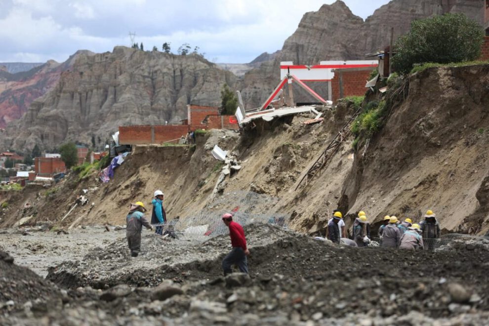 Obreros municipales trabajan cerca de casas colapsadas por la crecida de ríos en la zona Callapa, La Paz