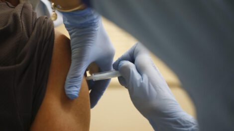 Una persona vacunándose contra la Covid-19 y gripe simultáneamente