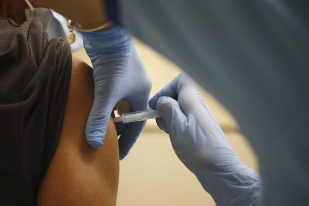 Una persona vacunándose contra la Covid-19 y gripe simultáneamente