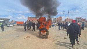 Incendio de un neumático y un grupo de personas