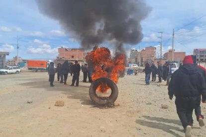 Incendio de un neumático y un grupo de personas